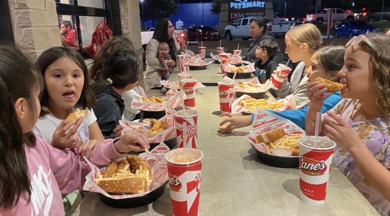 Children and adults sharing a meal and fellowship around a restaurant table