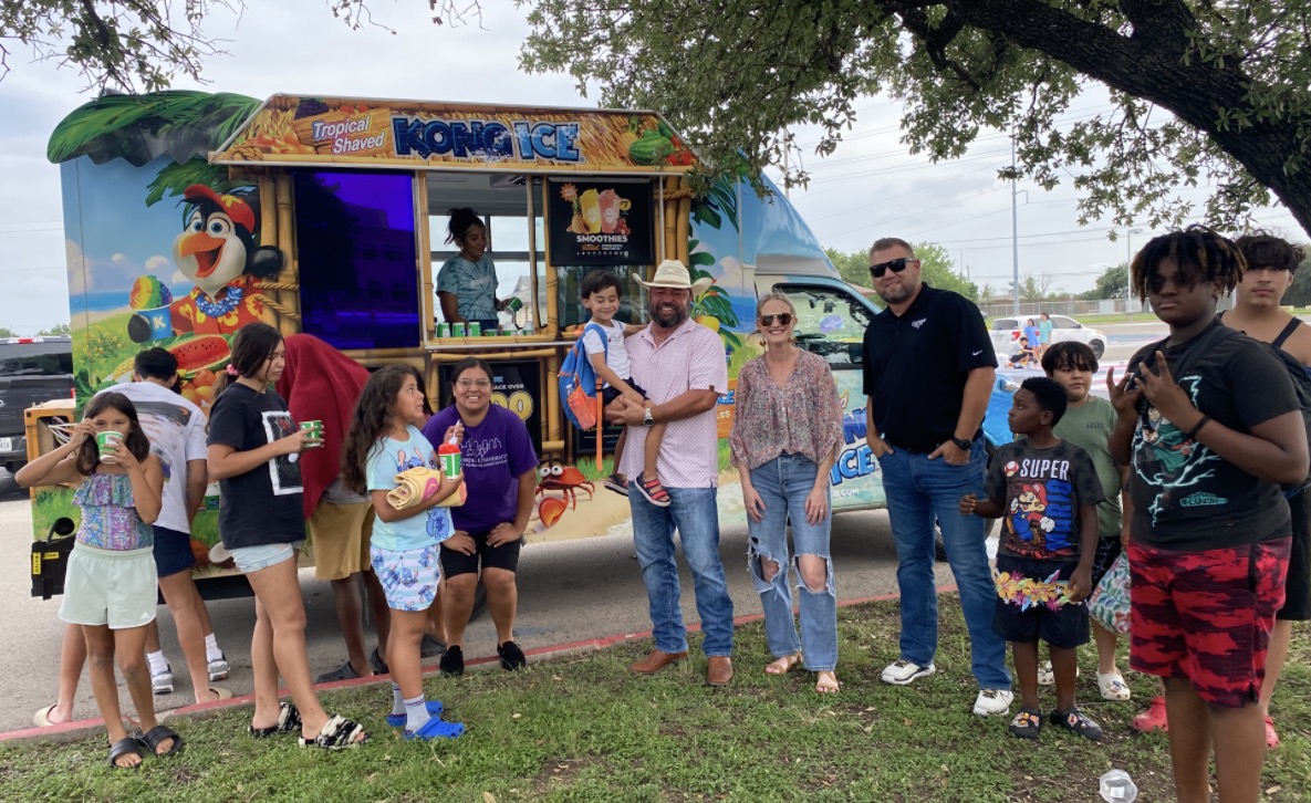 KINGDOM Kids children and adults enjoying shaved ice together at a Kona Ice truck
